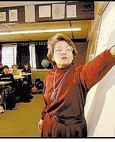 Ingrid Fotino uses an overhead projector while telling the story of her family's escape from Romania in the late 1940s. (Photo b